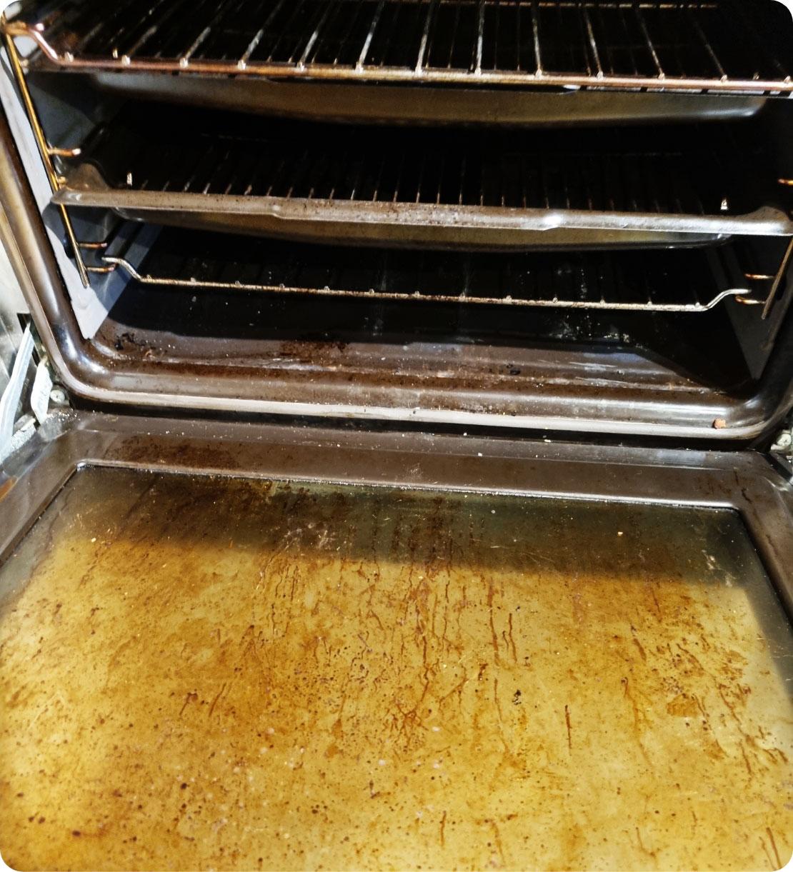 Open dirty oven showing accumulated grease and food residue.